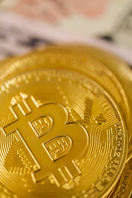 золотые слитки рядом с физической монетой биткойн